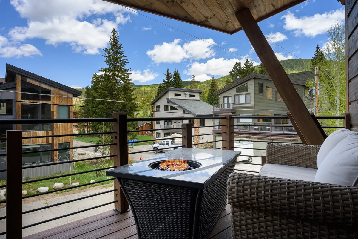 This exterior image features a cozy fire pit surrounded by outdoor seating, set amidst tall trees. The scene radiates warmth and is perfect for group gatherings, relaxation, and enjoying the surrounding nature—whether for sunset watching or stargazing at night.